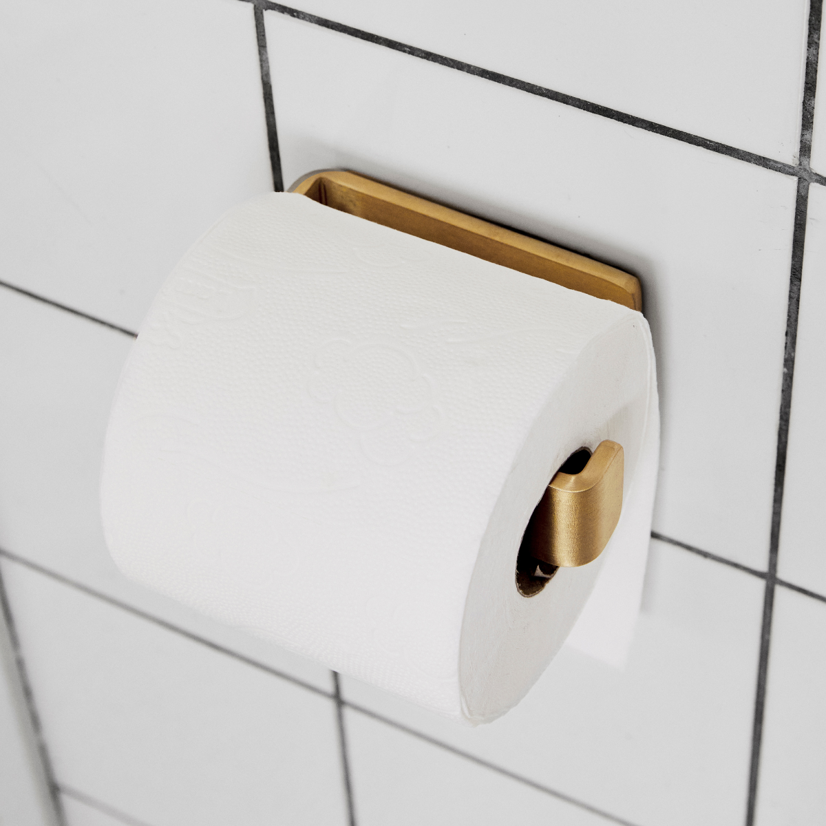 Tidløs og enkel toiletrulleholder i rå, massiv messing til dit badeværelse.